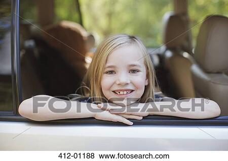 Stock Photo - Smiling girl leaning out car window. Fotosearch