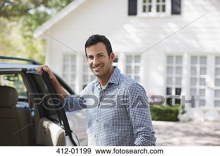 Stock Photo - Smiling man opening car door. Fotosearch