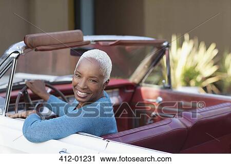 Smiling older woman driving convertible View Large Photo Image Stock Image - Smiling older woman driving convertible. Fotosearch