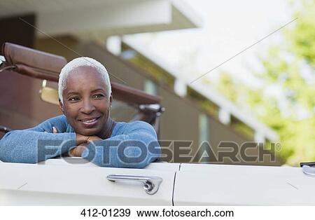 Smiling older woman sitting in convertible View Large Photo Image Stock Photo - Smiling older woman sitting in convertible. Fotosearch