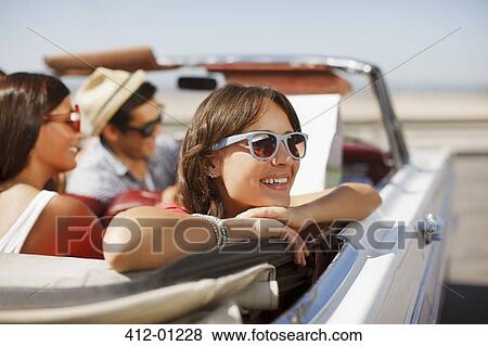 Smiling woman leaning out convertible View Large Photo Image Stock Photo - Smiling woman leaning out convertible. Fotosearch