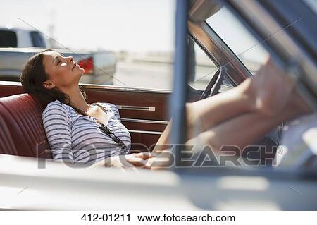 Smiling woman relaxing in convertible View Large Photo Image Stock Image - Smiling woman relaxing in convertible. Fotosearch