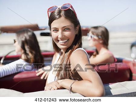 Smiling woman sitting in convertible View Large Photo Image Stock Image - Smiling woman sitting in convertible. Fotosearch