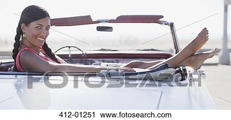 Smiling woman sitting in convertible View Large Photo Image Stock Image - Smiling woman sitting in convertible. Fotosearch