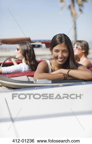 Smiling woman sitting in convertible View Large Photo Image Stock Photograph - Smiling woman sitting in convertible. Fotosearch