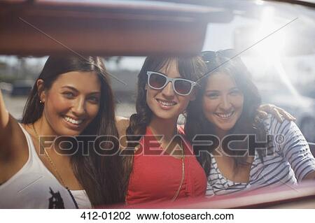 Smiling women driving convertible View Large Photo Image Stock Image - Smiling women driving convertible. Fotosearch