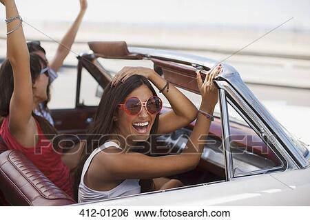 Smiling women driving convertible View Large Photo Image Stock Photograph - Smiling women driving convertible. Fotosearch