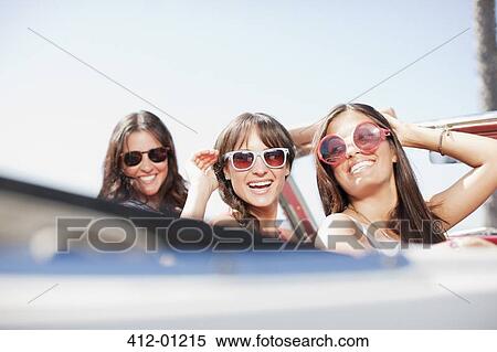 Smiling women driving convertible View Large Photo Image Stock Photography - Smiling women driving convertible. Fotosearch