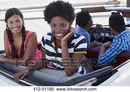 Smiling women sitting in convertible View Large Photo Image Stock Image - Smiling women sitting in convertible. Fotosearch
