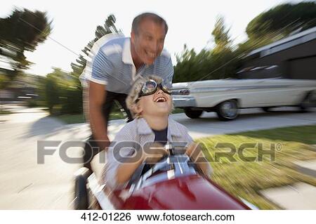 Time lapse view of father pushing son in go cart View Large Photo Image Stock Photograph - Time lapse view of father pushing son in go cart. Fotosearch