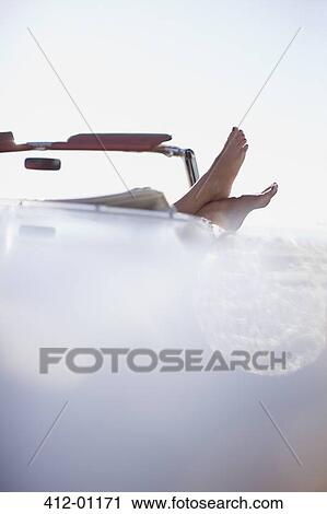 Woman's feet resting on convertibl View Large Photo Image Stock Image - Woman's feet resting on convertibl. Fotosearch