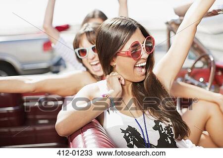 Women cheering in convertible View Large Photo Image Stock Image - Women cheering in convertible. Fotosearch