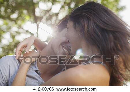 Close up of happy couple hugging View Large Photo Image Stock Photograph - Close up of happy couple hugging. Fotosearch