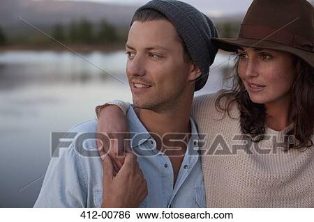 Stock Photograph - Close up of hugging couple at lake. Fotosearch