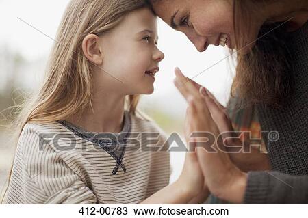 Stock Image - Close up of mother and daughter holding hands. Fotosearch