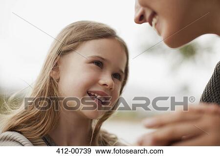 Close up of smiling daughter looking up at mother View Large Photo Image Stock Photo - Close up of smiling daughter looking up at mother. Fotosearch