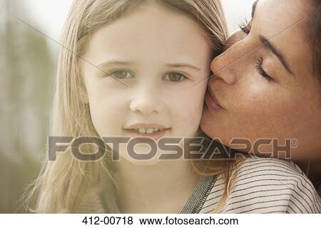 Close up portrait of mother kissing daughter's chee View Large Photo Image Stock Photo - Close up portrait of mother kissing daughter's chee. Fotosearch