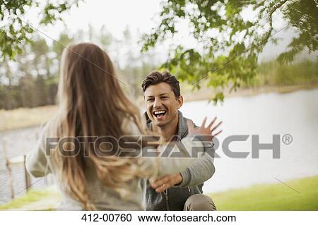 Daughter running toward smiling father with arms outstretched at lakeside View Large Photo Image Stock Image - Daughter running toward smiling father with arms outstretched at lakeside. Fotosearch
