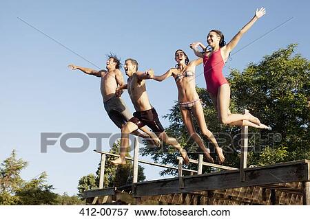 Friends jumping off dock View Large Photo Image Stock Photo - Friends jumping off dock. Fotosearch