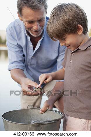 Grandfather and grandson with frog and bucket View Large Photo Image Stock Image - Grandfather and grandson with frog and bucket. Fotosearch