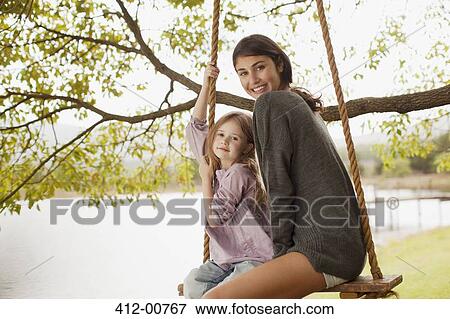 Portrait of mother and daughter on swing at lakeside View Large Photo Image Stock Photo - Portrait of mother and daughter on swing at lakeside. Fotosearch