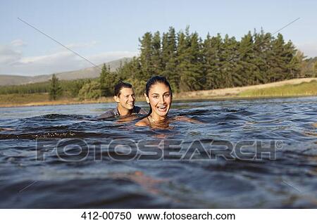 Portrait of smiling couple swimming in lake View Large Photo Image Stock Image - Portrait of smiling couple swimming in lake. Fotosearch