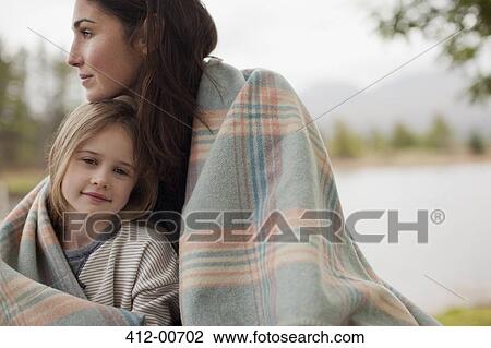 Portrait of smiling daughter wrapped in blanket with mother at lakeside View Large Photo Image Stock Image - Portrait of smiling daughter wrapped in blanket with mother at lakeside. Fotosearch