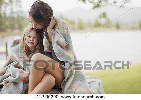 Portrait of smiling daughter wrapped in blanket with mother at lakeside View Large Photo Image Stock Image - Portrait of smiling daughter wrapped in blanket with mother at lakeside. Fotosearch
