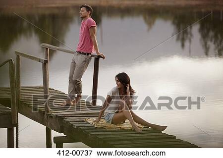 Stock Photo - Serene couple on dock over lake. Fotosearch