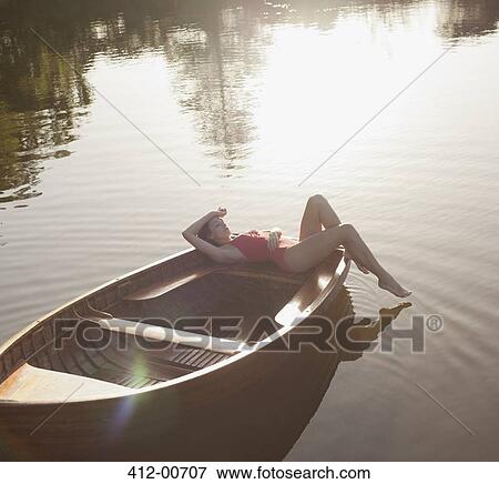 Serene woman sunbathing in boat on lake View Large Photo Image Stock Photo - Serene woman sunbathing in boat on lake. Fotosearch