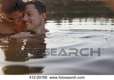 Smiling couple swimming in lake View Large Photo Image Stock Photograph - Smiling couple swimming in lake. Fotosearch