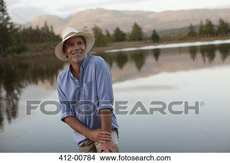 Smiling man at lakeside View Large Photo Image Picture - Smiling man at lakeside. Fotosearch