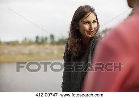 Smiling woman looking at man at lakeside View Large Photo Image Stock Photo - Smiling woman looking at man at lakeside. Fotosearch