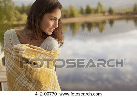 Smiling woman wrapped in blanket at lakeside View Large Photo Image Stock Image - Smiling woman wrapped in blanket at lakeside. Fotosearch