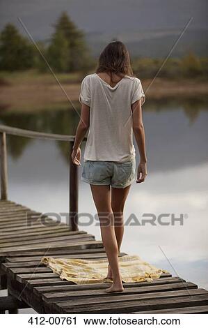 Woman walking toward blanket on dock over lake View Large Photo Image Stock Image - Woman walking toward blanket on dock over lake. Fotosearch