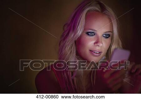 Close up of woman checking cell phone in dark View Large Photo Image Stock Image - Close up of woman checking cell phone in dark. Fotosearch