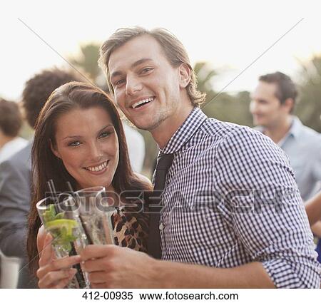 Stock Photography - Close up portrait of smiling couple drinking cocktails. Fotosearch