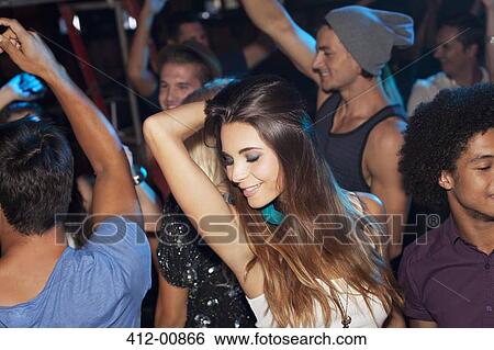 Confident woman dancing in crowd at nightclub View Large Photo Image Stock Photograph - Confident woman dancing in crowd at nightclub. Fotosearch
