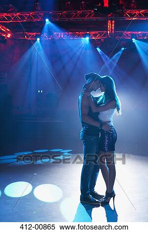 Stock Photography - Couple dancing and hugging on empty dance floor in nightclub. Fotosearch