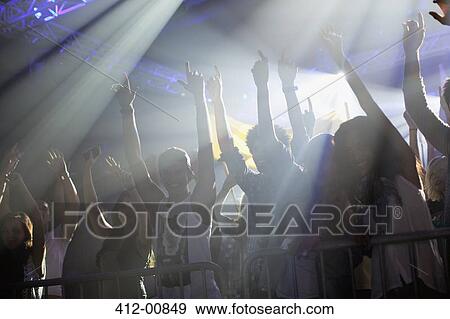 Crowd with arms raised behind railing at concert View Large Photo Image Stock Photo - Crowd with arms raised behind railing at concert. Fotosearch