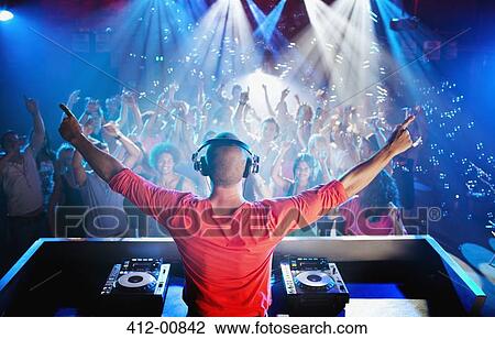 DJ with arms outstretched overlooking dance floor View Large Photo Image Stock Image - DJ with arms outstretched overlooking dance floor. Fotosearch