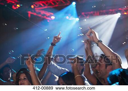 Enthusiastic crowd with arms raised on dance floor of nightclub View Large Photo Image Stock Photo - Enthusiastic crowd with arms raised on dance floor of nightclub. Fotosearch