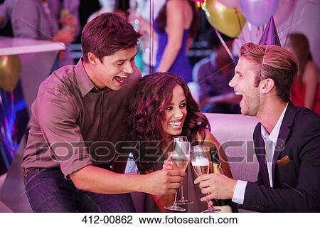 Enthusiastic friends toasting champagne flutes in nightclub View Large Photo Image Stock Image - Enthusiastic friends toasting champagne flutes in nightclub. Fotosearch