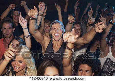 Enthusiastic man cheering in crowd at concert View Large Photo Image Stock Image - Enthusiastic man cheering in crowd at concert. Fotosearch