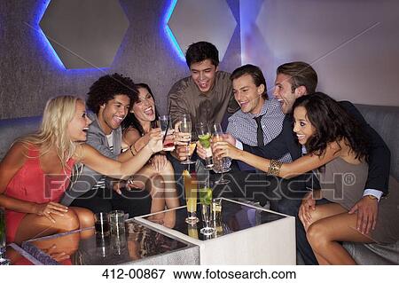 Friends toasting cocktails in nightclub View Large Photo Image Stock Photo - Friends toasting cocktails in nightclub. Fotosearch