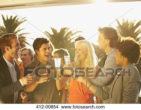 Friends toasting cocktails on sunny balcony View Large Photo Image Picture - Friends toasting cocktails on sunny balcony. Fotosearch