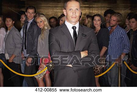 Portrait of serious bouncer with arms crossed in front of queue at nightclub View Large Photo Image Stock Photography - Portrait of serious bouncer with arms crossed in front of queue at nightclub. Fotosearch