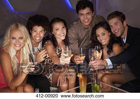 Portrait of smiling friends toasting cocktails in nightclub View Large Photo Image Stock Image - Portrait of smiling friends toasting cocktails in nightclub. Fotosearch
