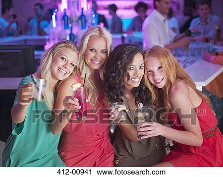 Portrait of smiling women with cocktails in nightclub View Large Photo Image Stock Image - Portrait of smiling women with cocktails in nightclub. Fotosearch