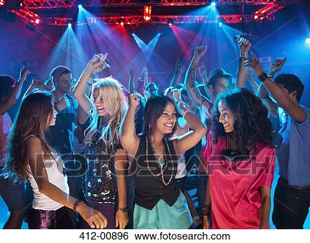 Stock Photograph - Smiling friends dancing on dance floor of nightclub. Fotosearch